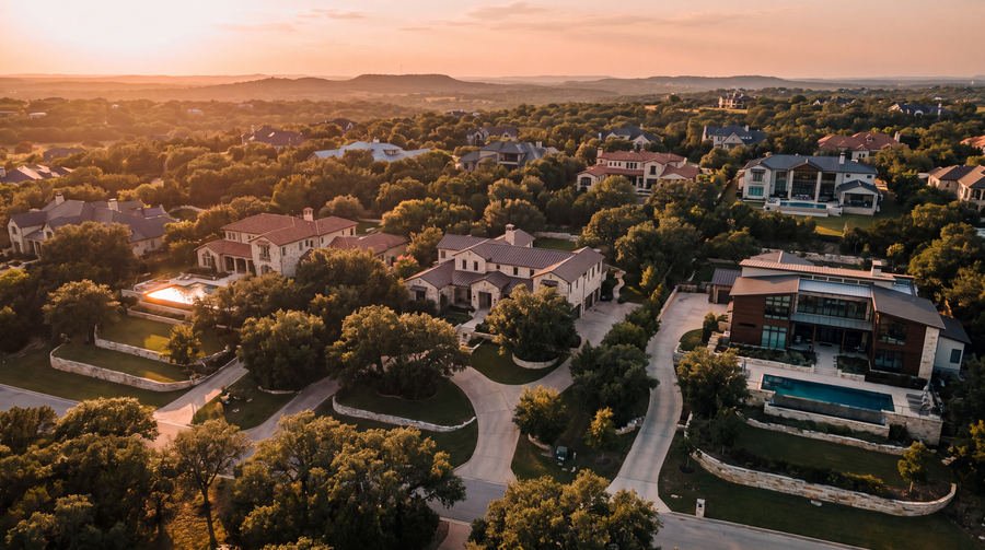 Aerial view of a wooded Hill Country estate neighbourhood at golden hour